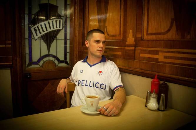 Model sitting in E. Pellici donning their limited edition football shirt