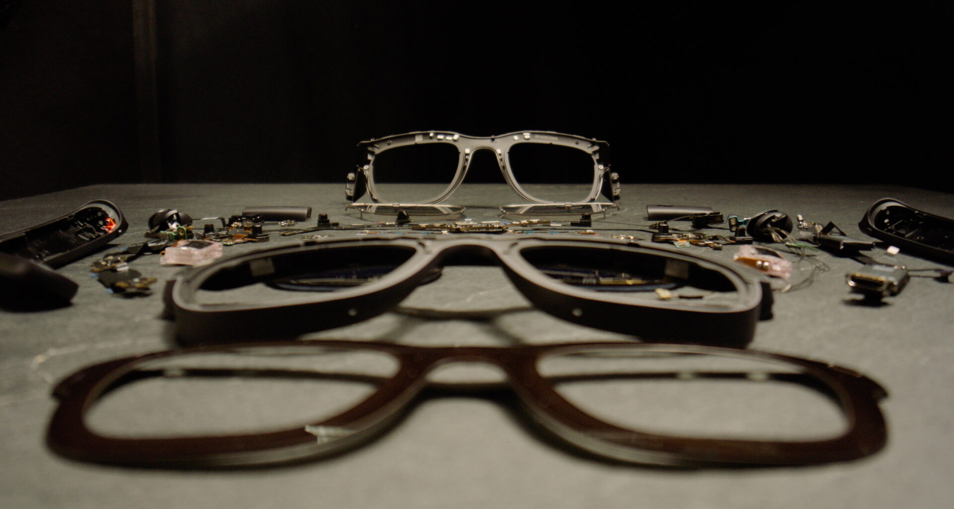 The Meta Orion AR glasses disassembled and sitting on top of a gray table
