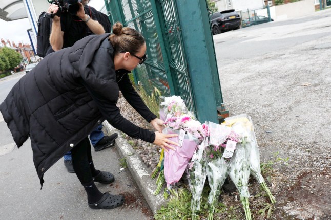 Woman lays floral tribute at scene of the crash.