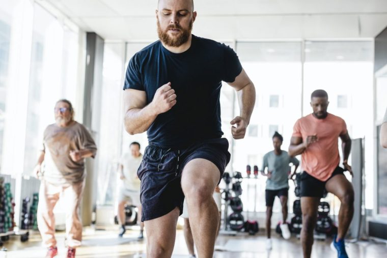 A man takes a running class at the gym