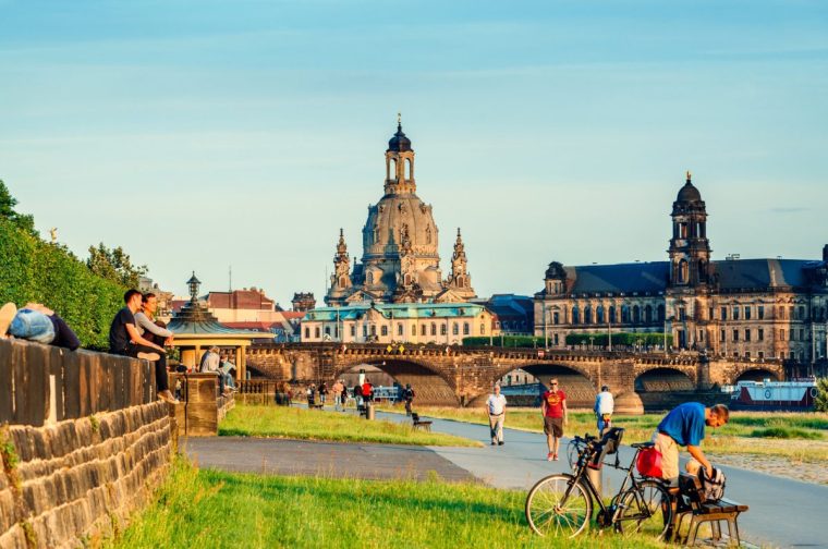 Dresden, Germany- June 17, 2014: Locals and Tourists enjoying the sunset over the promenade of the river Elbe in Dresden, Germany. The Frauenkirche cathedral (Church of Our Lady or Mother of God Church) in the background.