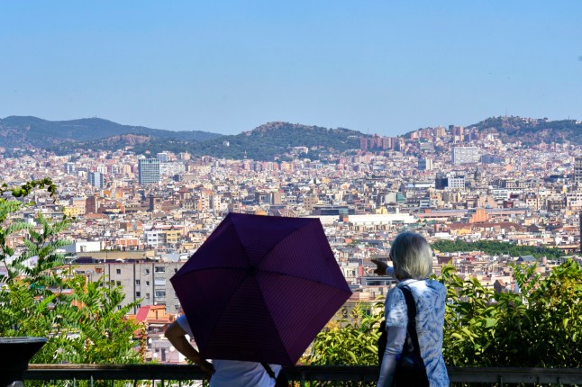 A tourist uses an umbrella to protect herself from the sun during a heat wave in Barcelona, Spain