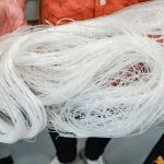 Someone holding long thin strips of white plastic.
