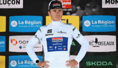 Remco Evenepoel with hands on hips looks pensive on the podium as best young rider