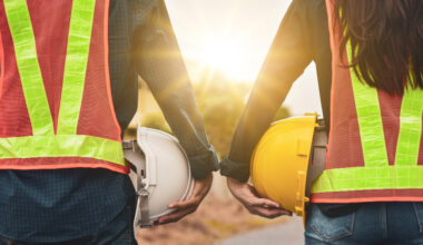 2 people holding helmets.