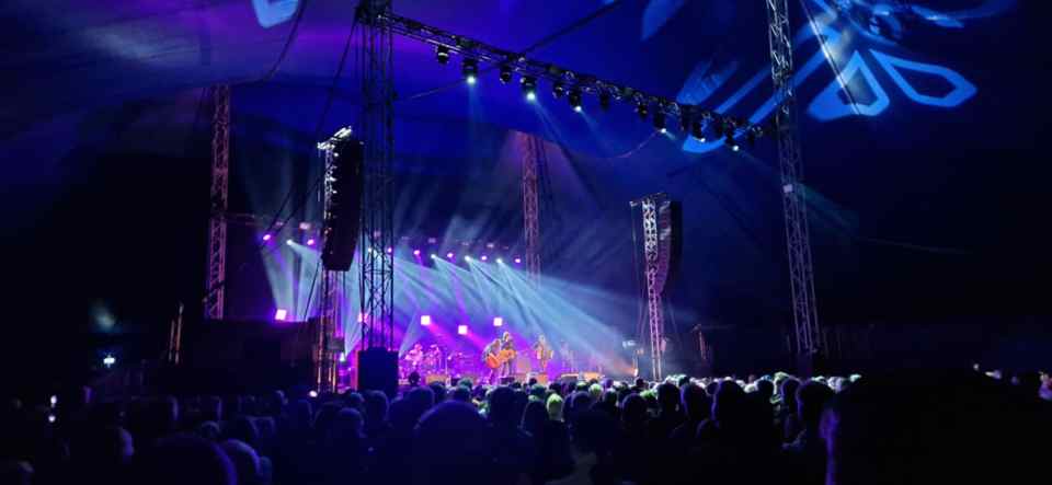 Band performing on stage in front of a large crowd.