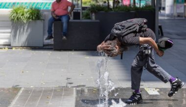 Hasan Grant uses a water jet at Dilworth Park to stay cool Wednesday during Philadelphia's heat wave.