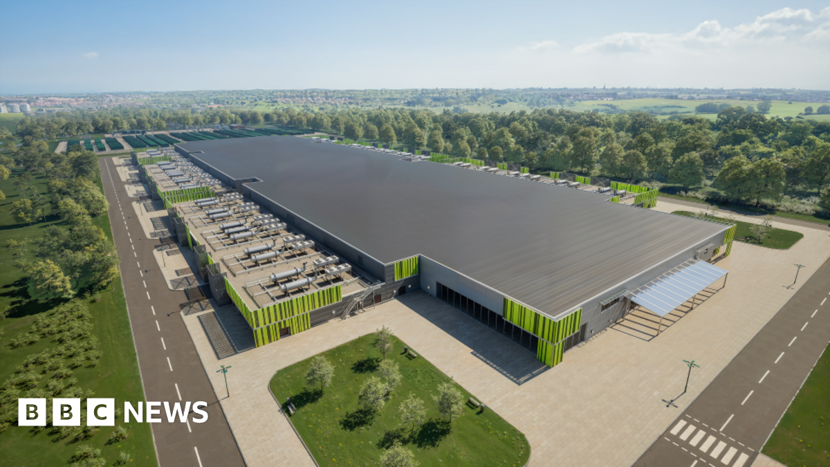 An artist's impression of the proposed new green AI energy centre in Ravenscraig - a large building with a grey roof and  green design on the walls. A car park is part of the site with entry roads around it.