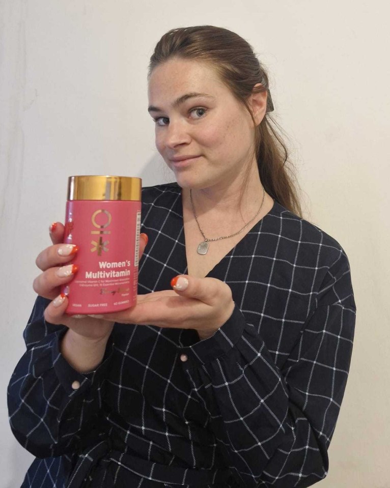 Woman holding a bottle of women's multivitamin gummies.