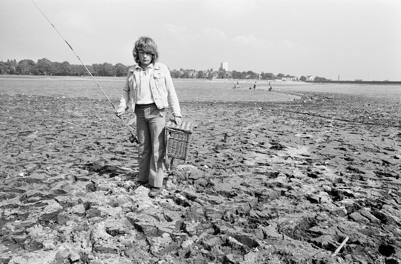 Young boy goes for a spot of fishing at dried out Edgbaston reservoir in Birmingham during the summer heatwave of 1976. 9th August 1976. (Photo by Birmingham Post and Mail Archive/Mirrorpix/Mirrorpix via Getty Images)