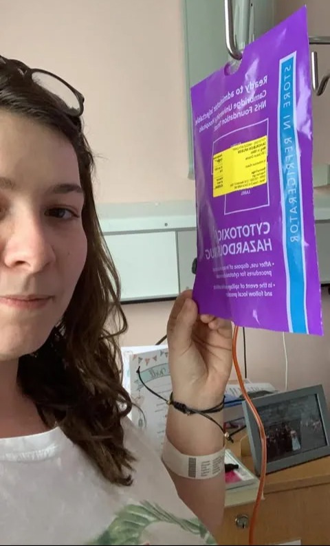 Woman holding a cytotoxic drug bag in a hospital.