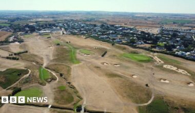 An aerial shot of a golf course in Cornwall showing very dry, brown areas of grass
