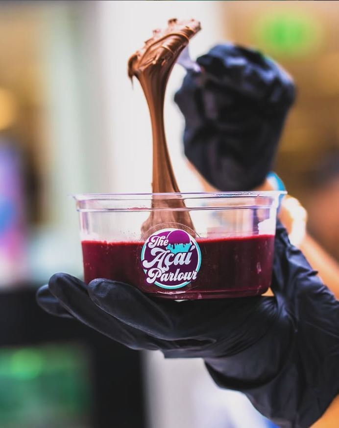 Acai bowl with chocolate being added.