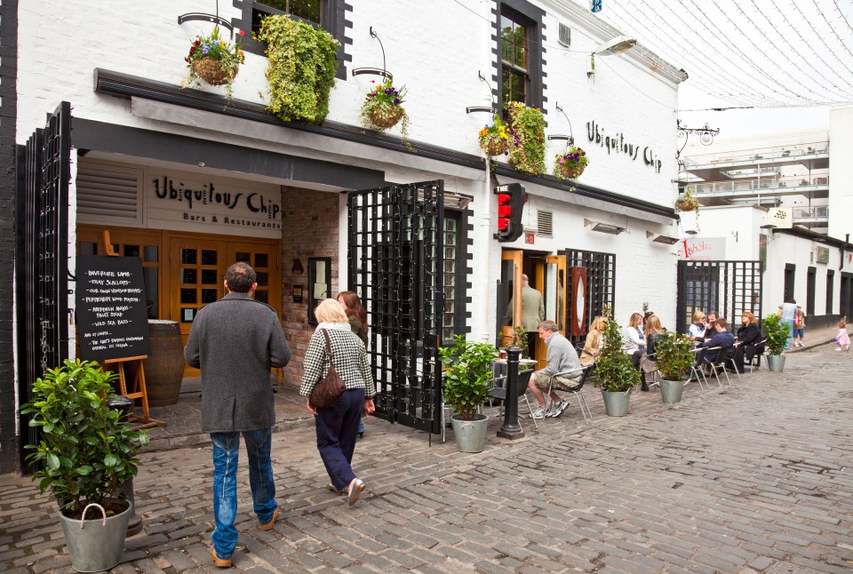 People dining and walking outside the Ubiquitous Chip restaurant in Glasgow.