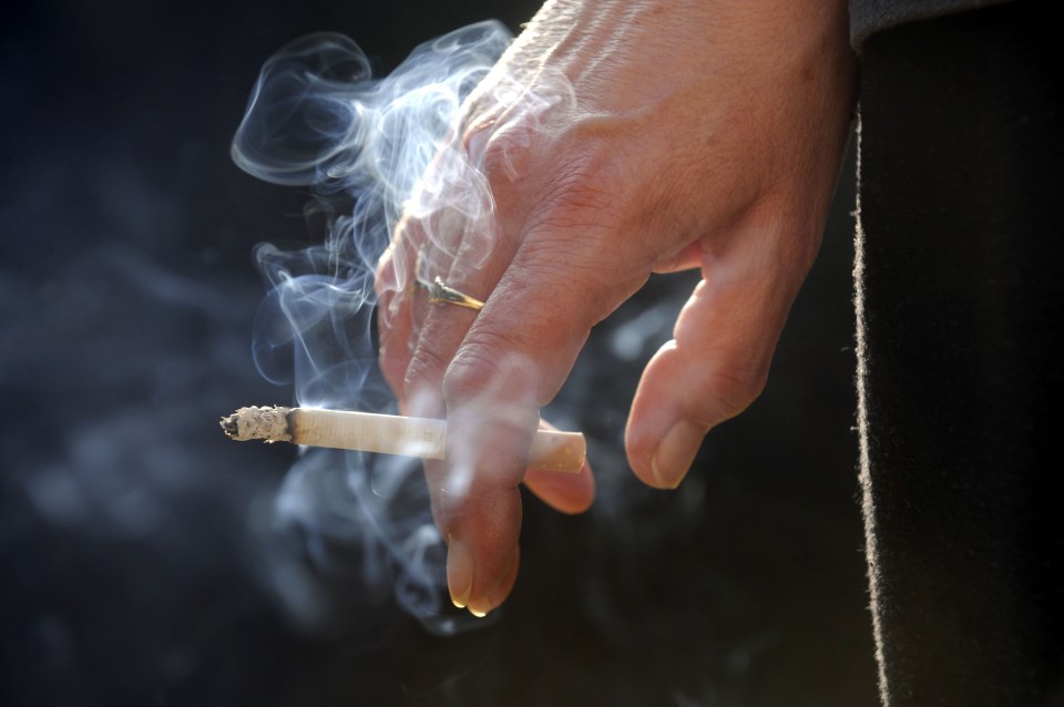 B457EX A LIT CIGARETTE SMOKING IN A WOMANS HAND.RE HEALTH HEALTHY LIFESTYLE LUNG DISEASE LUNGS SMOKERS HOSPITALS UK CANCER. Image shot 2008. Exact date unknown.