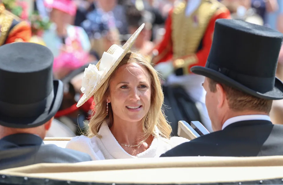 Harriet Sperling riding in a carriage with Peter Phillips at Royal Ascot wearing a floral hat