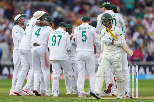 South Africa players celebrate as Australia’s Alex Carey, right, walks off the field after losing his wicket.