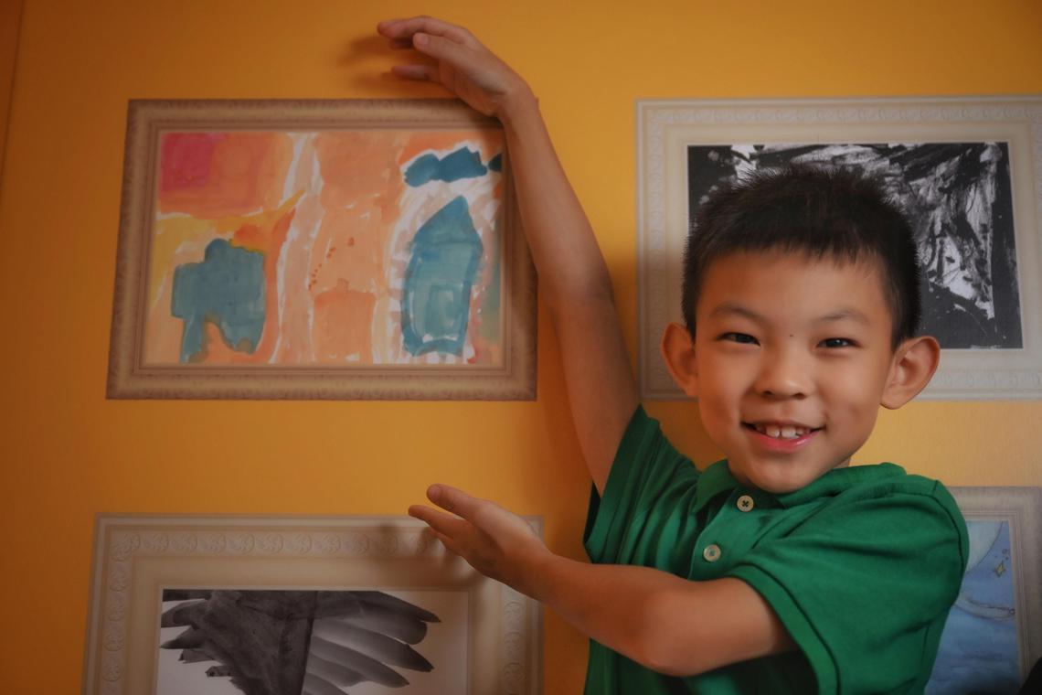 Kendric Chai,8  with his artwork exhibited at the SELebrate! ? The Colours of Emotion: A Journey in Art exhibition in Bedok library on June 20, 2025.