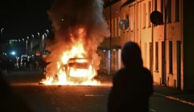 June 10, 2025: A vehicle burns as PSNI riot squad officers battled protesters throwing projectiles in Ballymena, Northern Ireland.
