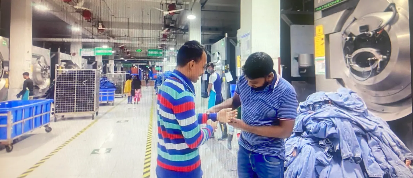 A man shows his colleague his new prosthetic arm at a garment factory in Bangladesh