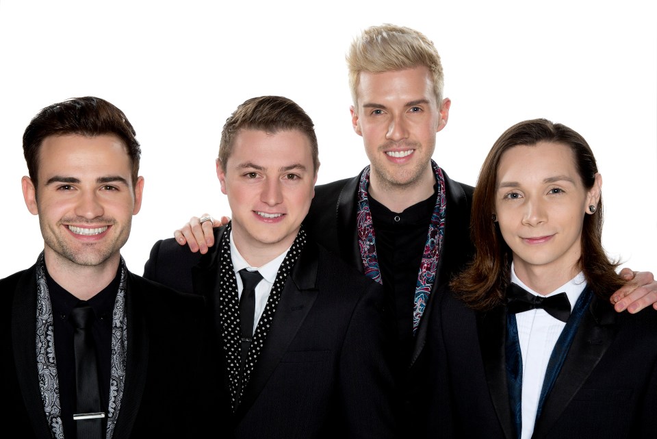 Four men in suits smiling for a photo.