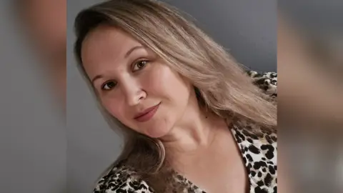 BBC Women with long hair smiling at the camera in a selfie mode.