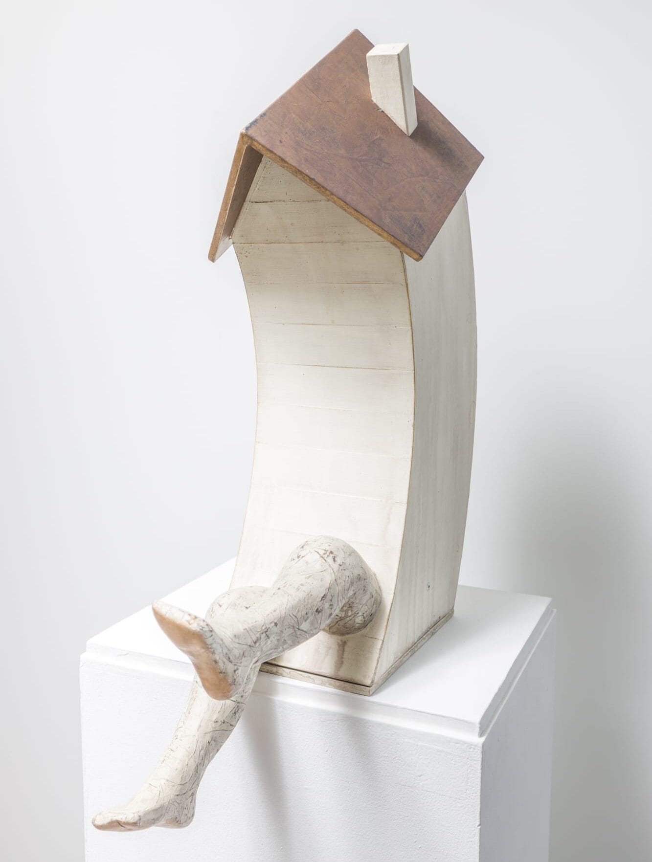 a small sculpture of a small building, seated, with two legs
