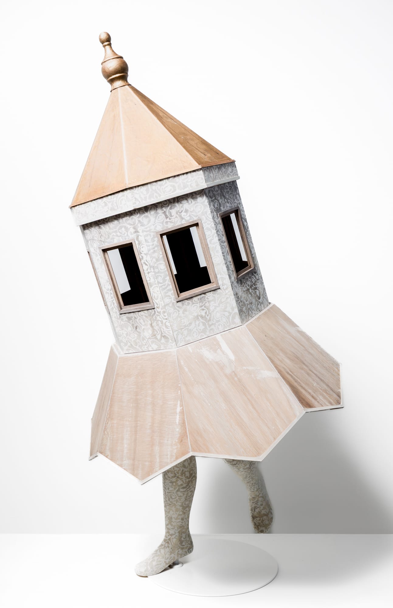 a small sculpture of a small building with two legs