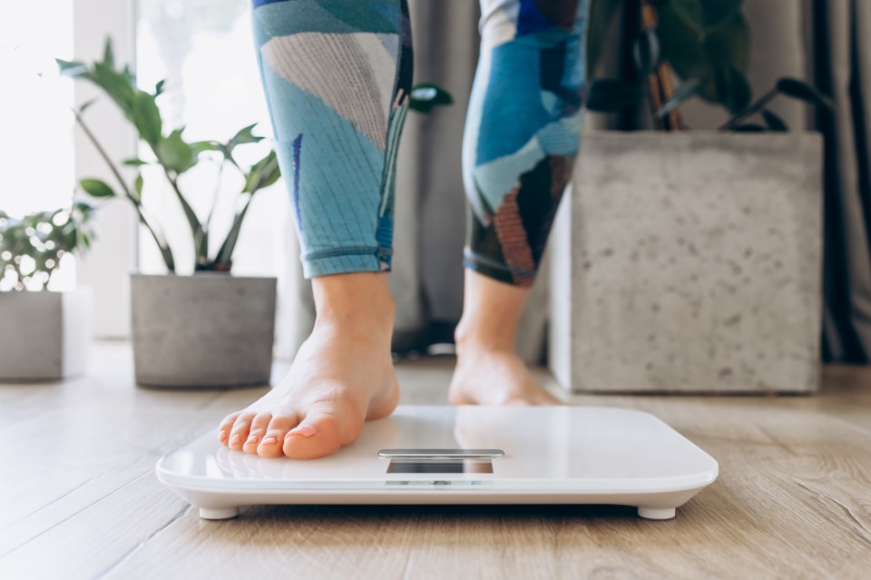 Woman's bare feet on a weight scale.