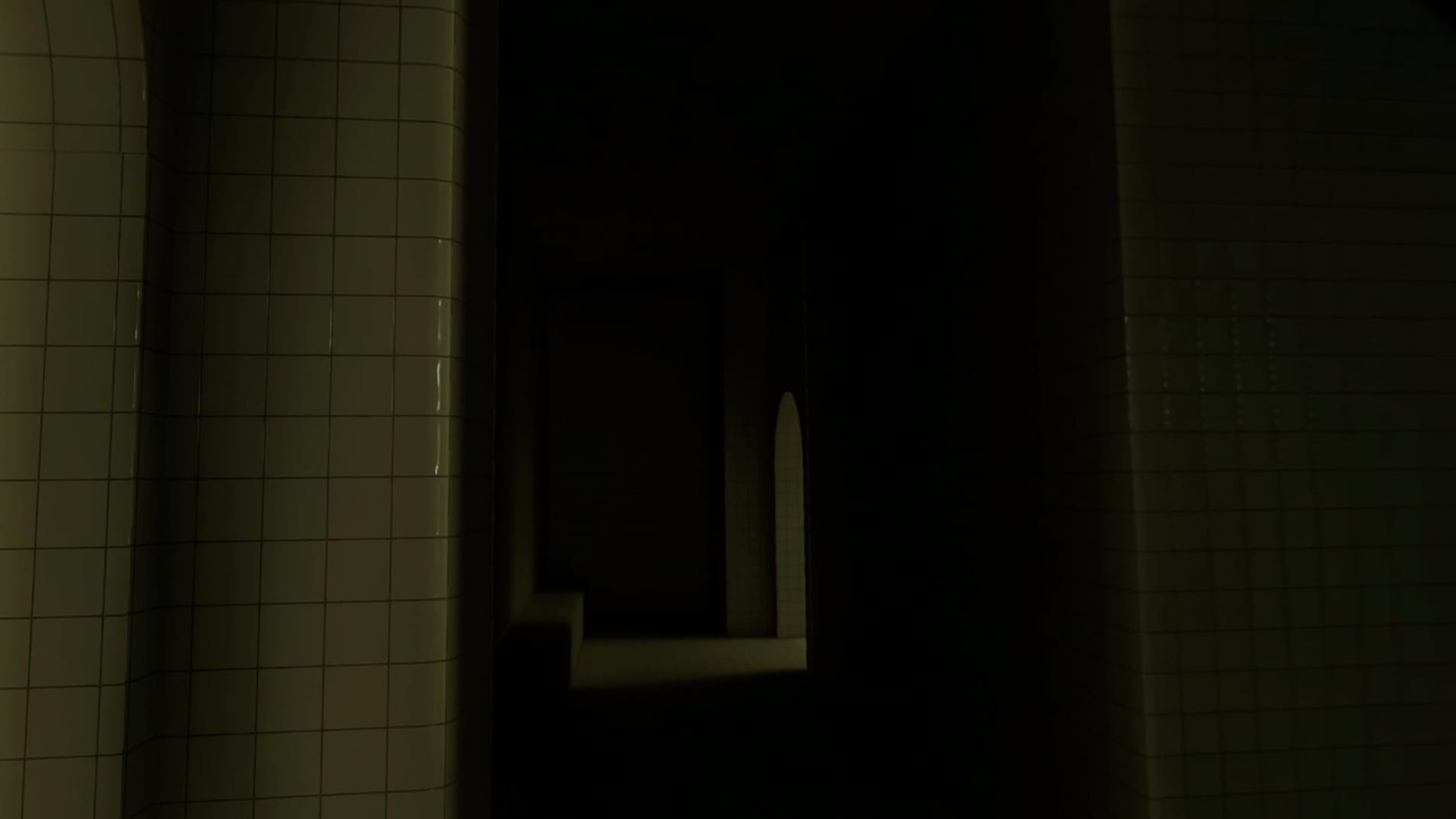 A dark liminal hallway with a bit of light shining through a doorway