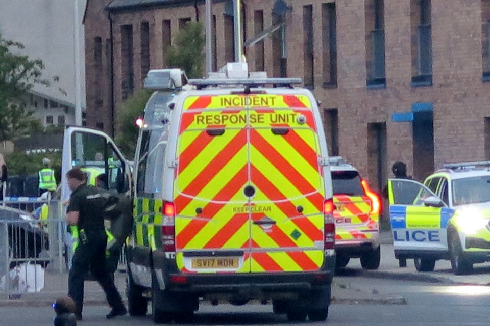 Police incident response unit van and police cars at Pennywell Gardens in Edinburgh.