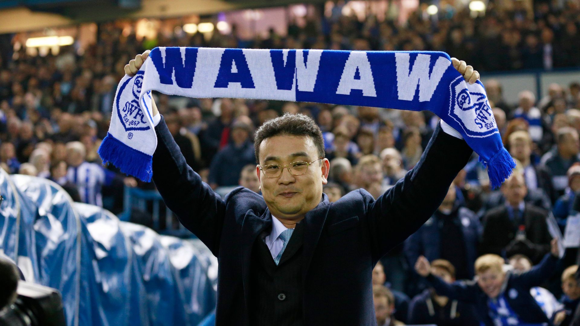 Dejphon Chansiri holding a Sheffield Wednesday scarf above his head