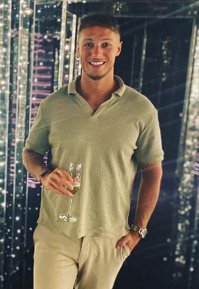 Man in light green shirt holding a glass of champagne.