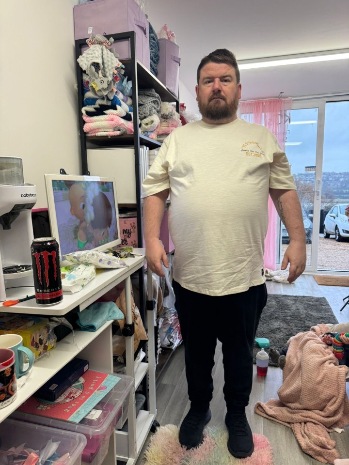 Man standing in a cluttered room.