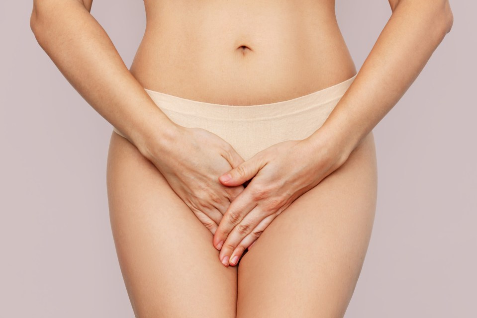 Woman holding her crotch, experiencing pain.