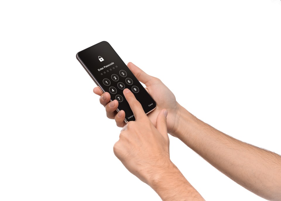 Hands entering a passcode on a smartphone.