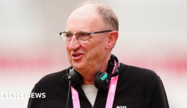 Jonathan Agnew, from BBC Sport, seen during the Rothesay International test series match at Trent Bridge, Nottingham, this year. He is wearing a zip-up black top and has a lanyard and microphones.
