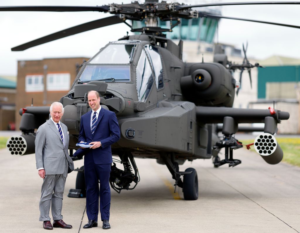 prince wiliam standing in front of helicopter with king charles 