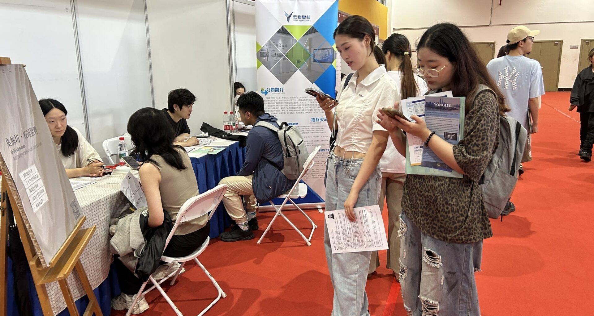 Students looking at a job ad at an employment fair in Shanghai.
