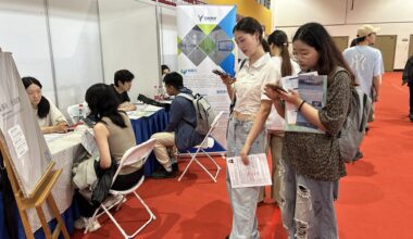 Students looking at a job ad at an employment fair in Shanghai.
