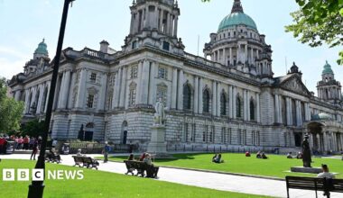 People sitting at Belfast City Hall on a sunny day