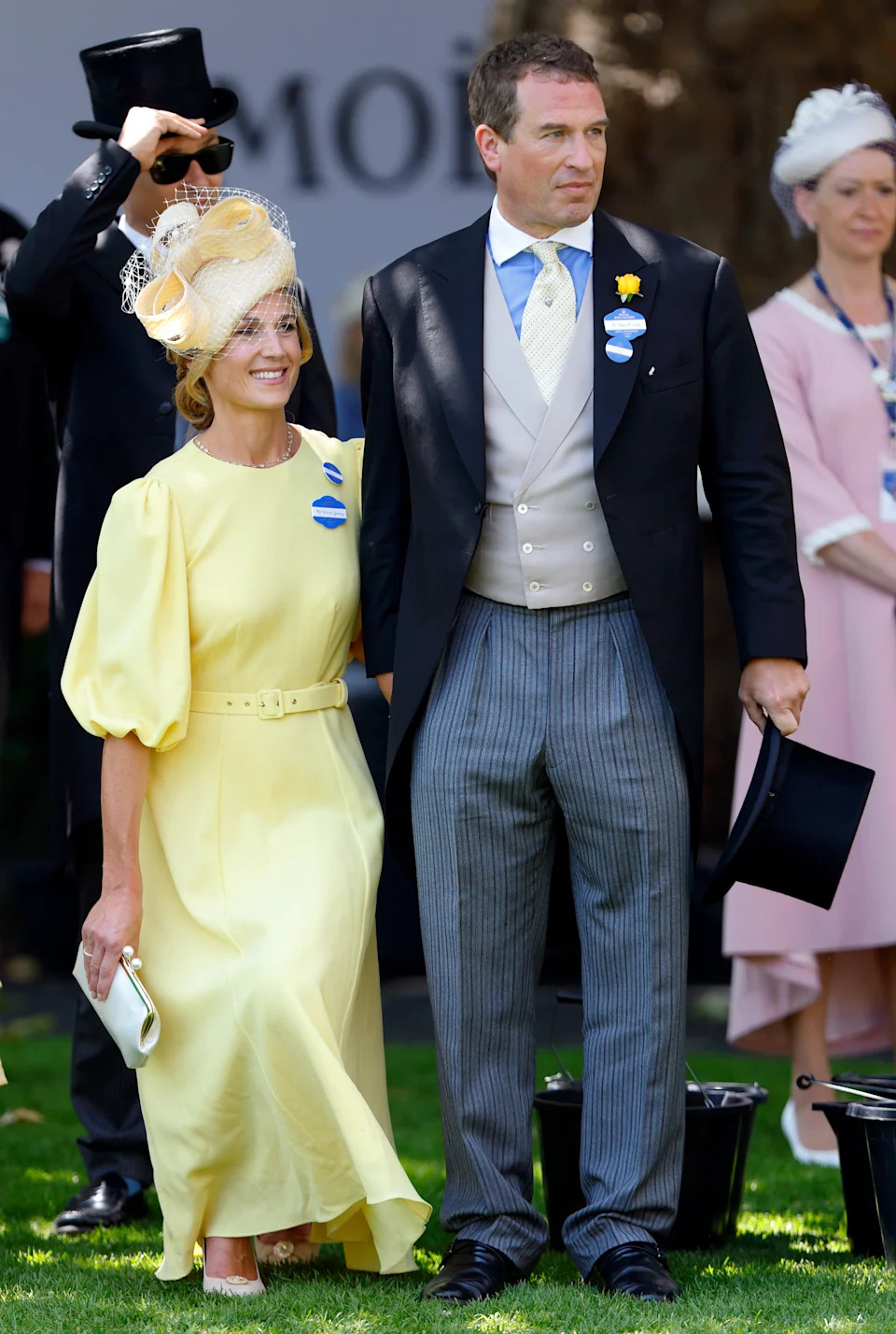 Harriet Sperling wearing a yellow dress curtesying next to Peter Phillips