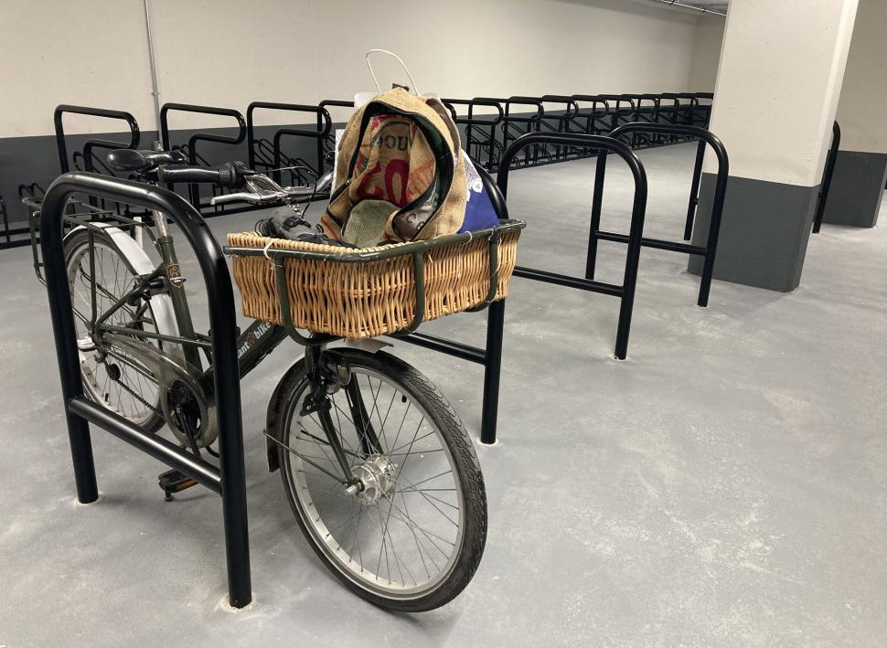 An Elephant cargo bike with basket parked against a Sheffield stand in Park Street cycle park, Cambridge