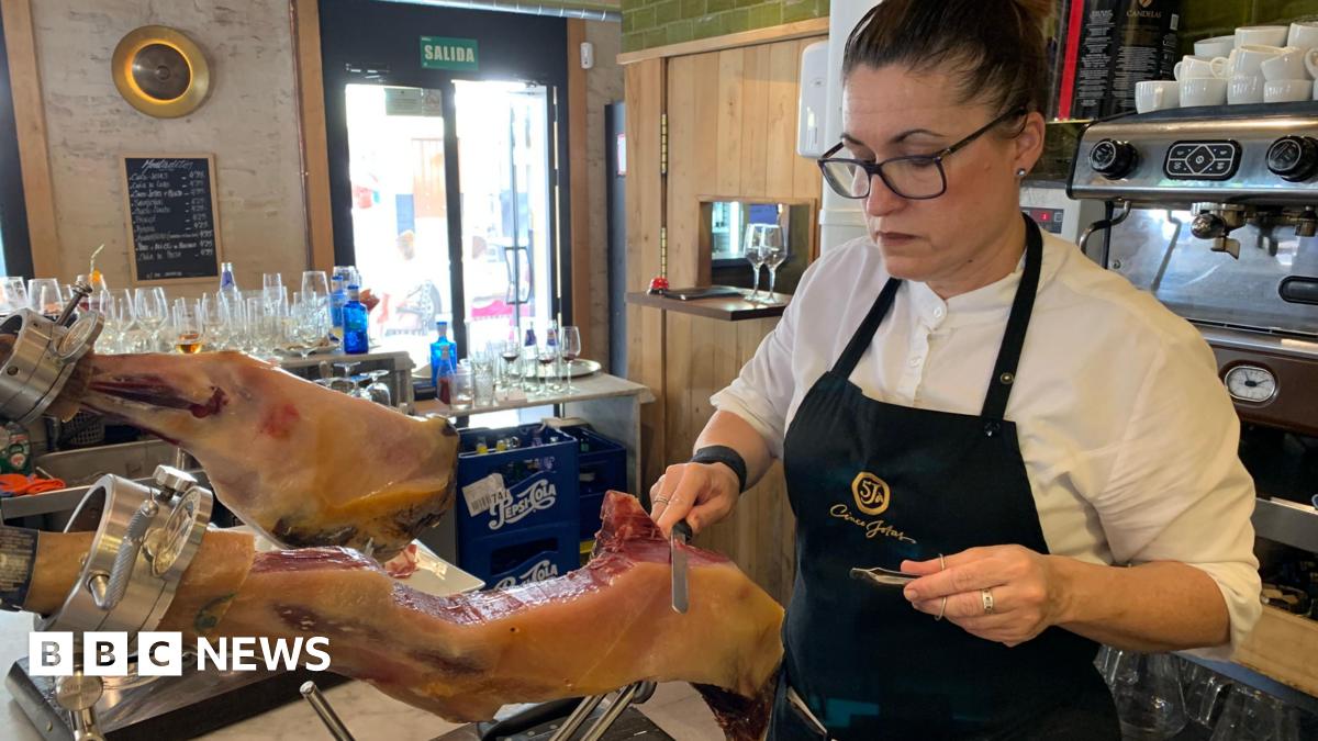 A leg of Spanish ham, or jamon, being carved at a bar in Seville