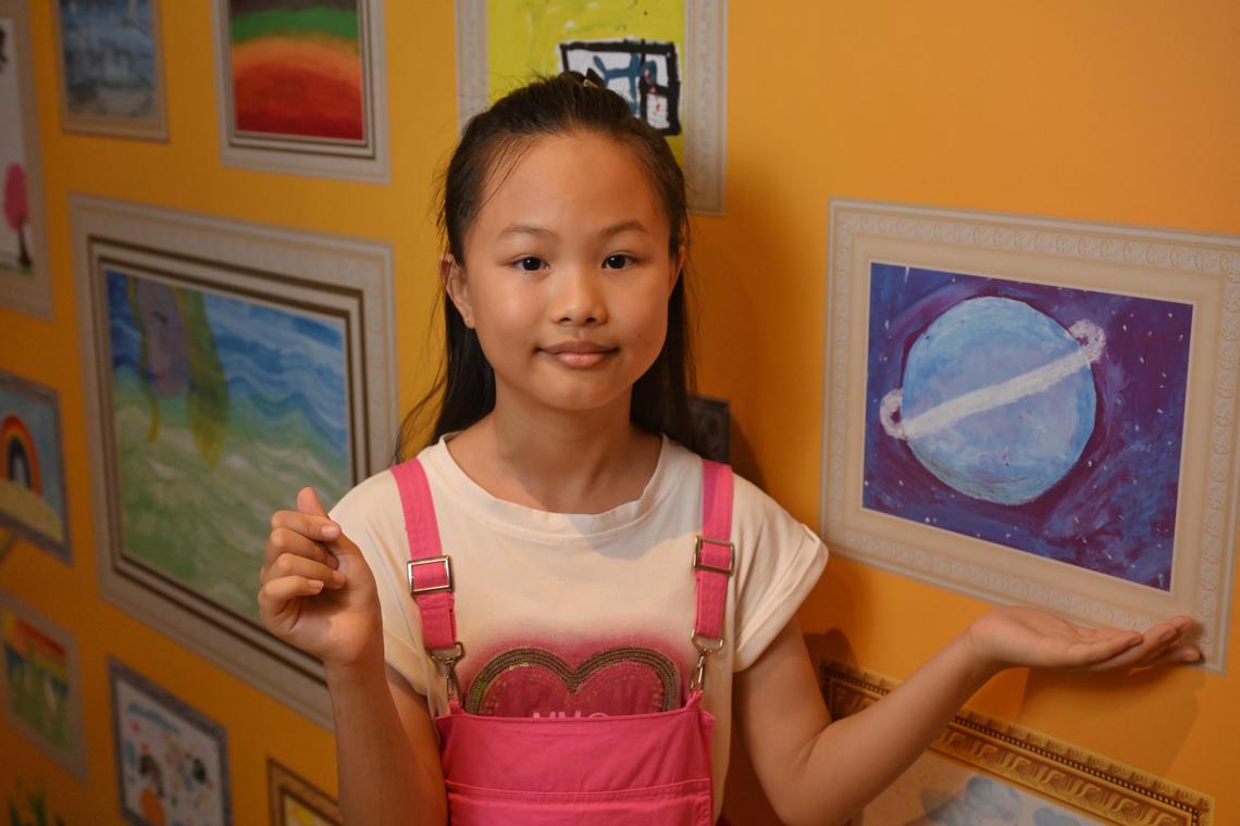 Chen Yening, 10  with her artwork exhibited at the SELebrate! ? The Colours of Emotion: A Journey in Art exhibition in Bedok library on June 20, 2025.