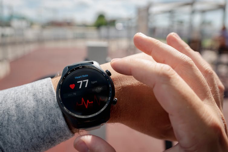 A person checks their heart rate on their fitness watch.