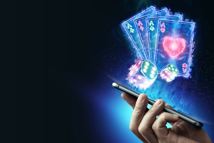 Hologram of playing cards and dice above a smartphone screen.