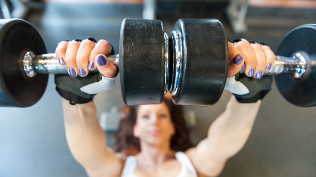 woman on bench lifts weights
