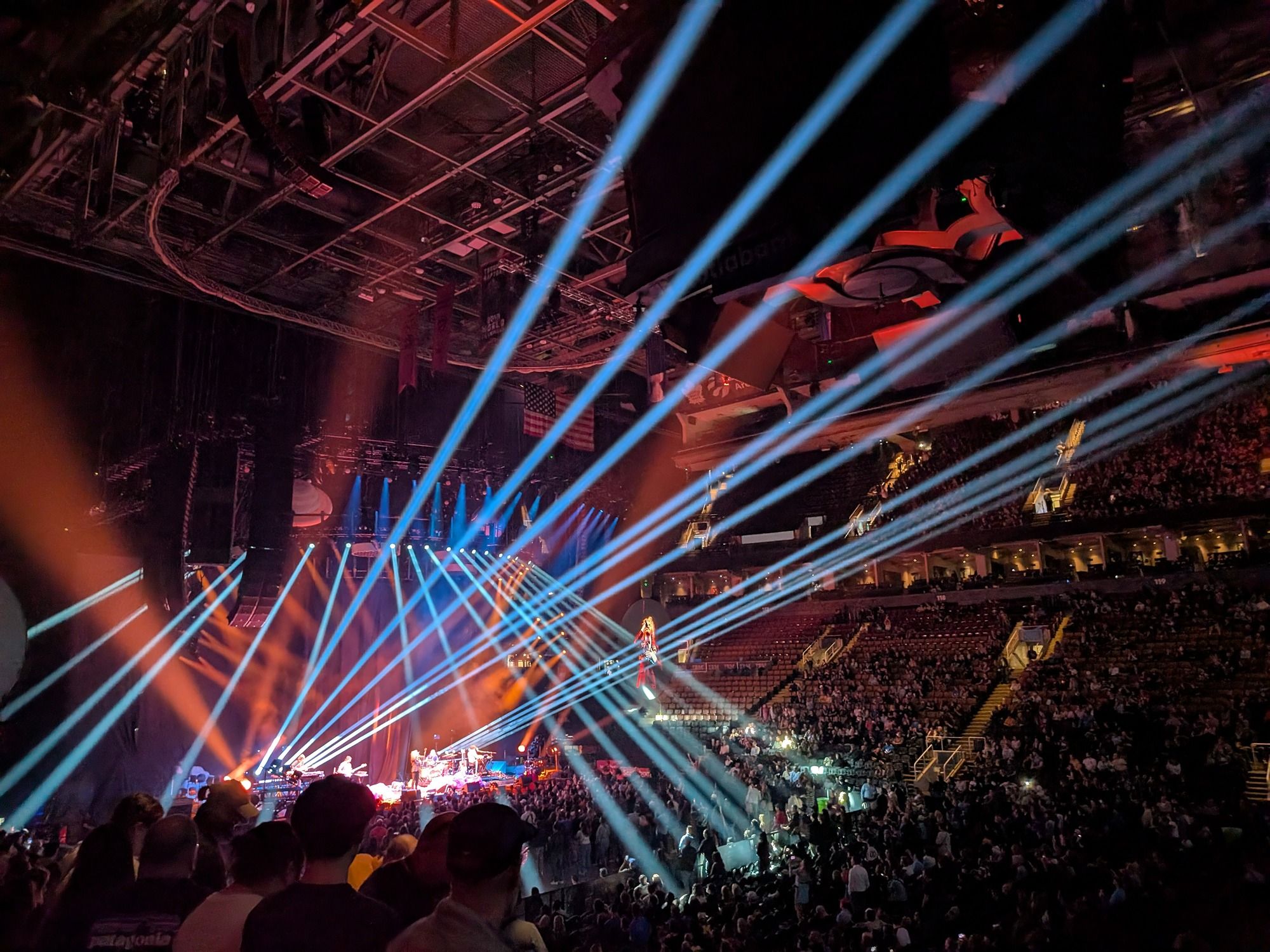 A photo of a concert with light beams emitting from the stage