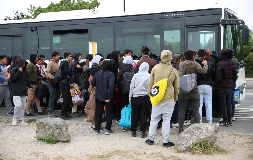 Migrants waiting to board a bus.